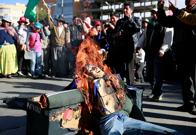 Demonstrators burn an effigy depicting Bolivia's President Evo Morales during a protest, who say they are demanding for better infrastructure and development in El Alto, Bolivia, October 12, 2016. (Photo by David Mercado/Reuters)