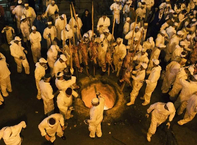 Members of the Samaritan sect place large sheep skewers into an oven during a traditional Passover sacrifice ceremony on Mount Gerizim, near the West Bank city of Nablus April 23, 2013. The Samaritans, who trace their roots to the Biblical kingdom of Israel in what is now the northern occupied West Bank, observe religious practices similar to those of Judaism. (Photo by Nir Elias/Reuters)