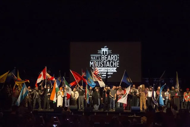Contestants wave flags to commence the 2015 Just For Men National Beard & Moustache Championships at the Kings Theater in the Brooklyn borough of New York City, November 7, 2015. (Photo by Elizabeth Shafiroff/Reuters)