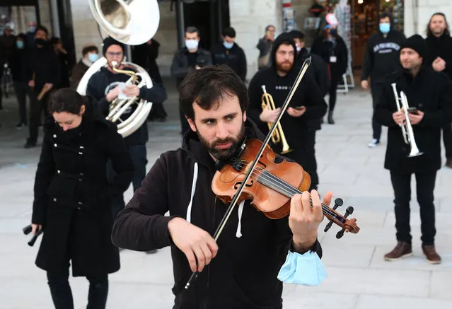 Professional musicians dressed in black perform on the Place of Freedom in Bayonne, southwestern France, Saturday, November 28, 2020, as they stage a protest against the nation wide lockdown. They are not authorized to resume their activities in the measures announced by President Macron. (Photo by Bob Edme/AP Photo)