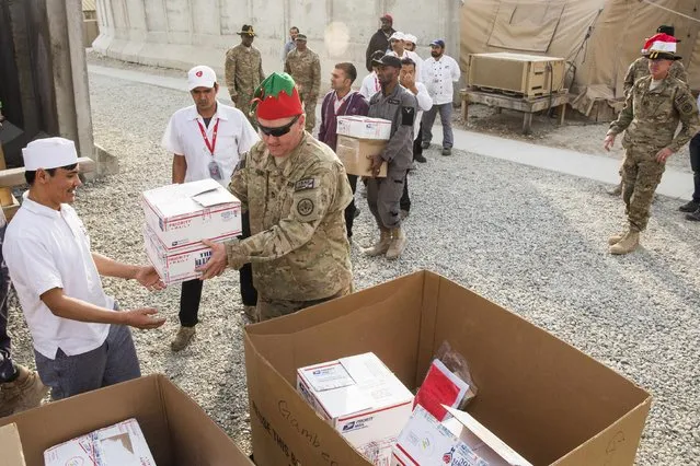 U.S. soldiers from the 3rd Cavalry Regiment pass out care packages and Christmas stockings to fellow soldiers and workers on forward operating base Gamberi in the Laghman province of Afghanistan December 24, 2014. (Photo by Lucas Jackson/Reuters)