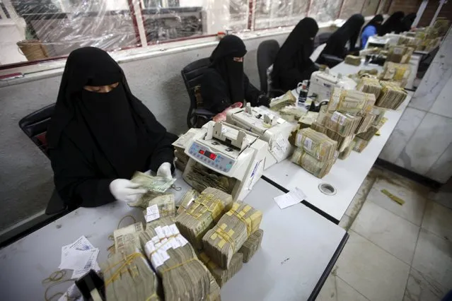 Money exchangers count stacks of Yemeni rials in of the Central Bank of Yemen in Sanaa, Yemen, November 15, 2015. (Photo by Mohamed al-Sayaghi/Reuters)