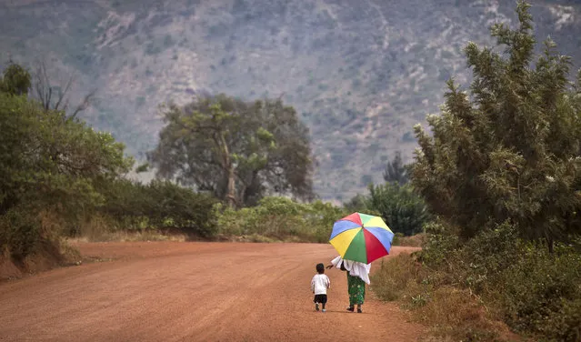 A mother reaches out to hold the hand of her young daughter, as they walk home after a church service in the village of Rwinkwavu, near to Akagera National Park, in Rwanda on September 6, 2015. The Protestant Council of Rwanda in Feb. 2023 has directed all health facilities run by its members to stop carrying out all abortions, further limiting access to the procedure in the largely Christian nation of 13 million people. (Photo by Ben Curtis/AP Photo)