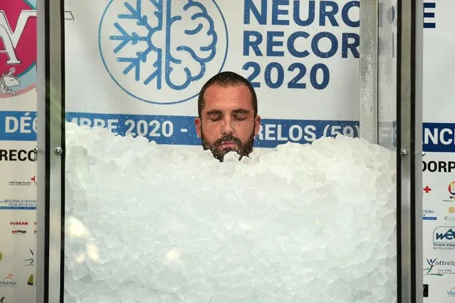 French Romain Vandendorpe closes his eyes as he tries to break the world record for the longest full body contact with ice cubes, in Wattrelos, northern France, on December 19, 2020. (Photo by Francois Lo Presti/AFP Photo)