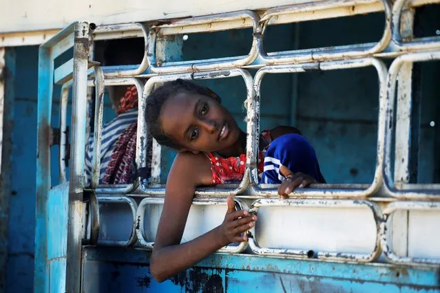 An Ethiopian refugee looks out of a bus window which transports her from the Hamdeyat refugee transit camp, which houses refugees fleeing the fighting in the Tigray region to the Um Rakuba refugees camp, in Sudan, December 1, 2020. (Photo by Baz Ratner/Reuters)