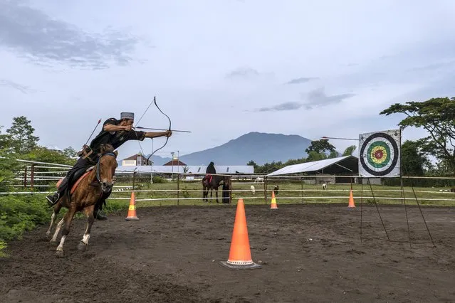 Fikri, takes part in horseback archery practice at the islamic boarding school Al-Fatah Temboro during the holy month of Ramadan on April 03, 2023 in Magetan, East Java, Indonesia. Al-Fatah Islamic Boarding School was founded in 1950 by KH. Kholid Umar, also known as Kyai Mahmud. Islamic boarding schools in Indonesia have around 22,000 students, including those from neighbouring countries in Southeast Asia, such as Malaysia, Brunei and Thailand. The Al-Fatah boarding school occupies a 50-hectare site in Temboro Village, Karas District, Magetan, East Java. It is the largest center for developing the ideology of the Tablighi Jamaat in Southeast Asia. The main goal of the Al-Fatah Islamic Boarding School is to learn about the Prophet, produce religious experts, spread Islam to all walks of life, improve oneself and uphold the da'wah journey of Allah's Apostle. The school's magnitude of the influence of religion on the lives of residents in Temboro has made this area known as the “Village of Medina”. Students at the Pesantren, also known as “Santri”, are separated from their families and spend their days studying Islamic scriptures, reading the Quran and learning Arabic in addition to other activities which begins with the morning prayer at 4am till midnight. (Photo by Ulet Ifansasti/Getty Images)
