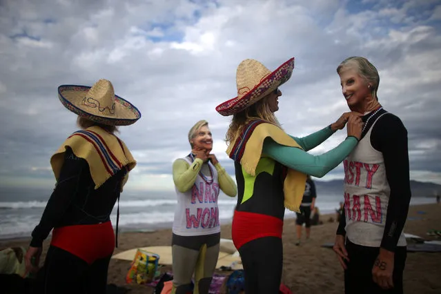 Daniela Burza, 45, (2nd L) and Karen Stuhr, 46, (R) wear Nasty Woman t-shirts and masks of U.S. Democratic presidential nominee Hillary Clinton as Liz Montgomery, 44, (L) and Rebecca Alber, 46, portray Bad Hombres, as they prepare to compete during the Haunted Heats Halloween Surf Contest in Santa Monica, California, U.S., October 29, 2016. (Photo by Lucy Nicholson/Reuters)