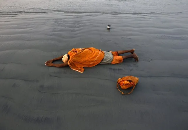 A “Sadhu”, or a Hindu holy man, offers prayers after taking a dip at the confluence of the river Ganges and the Bay of Bengal, ahead of the Makar Sankranti festival at Sagar Island, south of Kolkata January 13, 2015. (Photo by Rupak De Chowdhuri/Reuters)