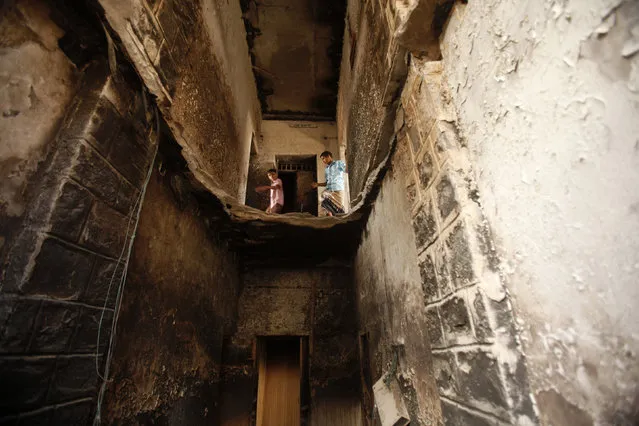 Boys walk in a house destroyed by an air strike last year that was targeting al Qaeda-linked militants, in the southern Yemeni town of Jaar February 1, 2013. (Photo by Khaled Abdullah/Reuters)