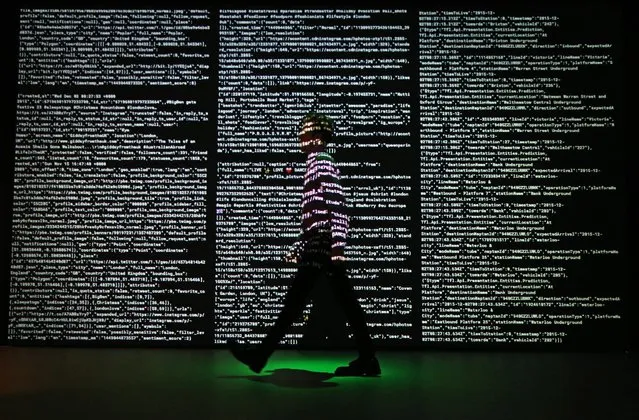 A staff member passes a projection of live data feeds from (L-R) Twitter, Instagram and Transport for London at the Big Bang Data exhibition at Somerset House on December 2, 2015 in London, England. (Photo by Peter Macdiarmid/Getty Images for Somerset House)