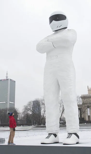 In this image released on Thursday, January 29 2015, Top Gear's The Stig, unveils a 10 metre high statue of himself, which has been created by BBC Worldwide, outside The Palace of Science and Culture in Warsaw, Poland to mark the launch of new global channel, BBC Brit which makes its debut on 1st February. The 10 metre high statue arrived in Poland after a 3-day road trip through Europe via Amsterdam and Berlin. (Photo by Tim Anderson/BBC via AP Images)