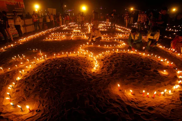 Devotees light candles at the banks of the Ganga river on the occasion of the annual Hindu festival of “Karthik Purnima” or full moon night, in Allahabad, India, November 14, 2016. (Photo by Jitendra Prakash/Reuters)
