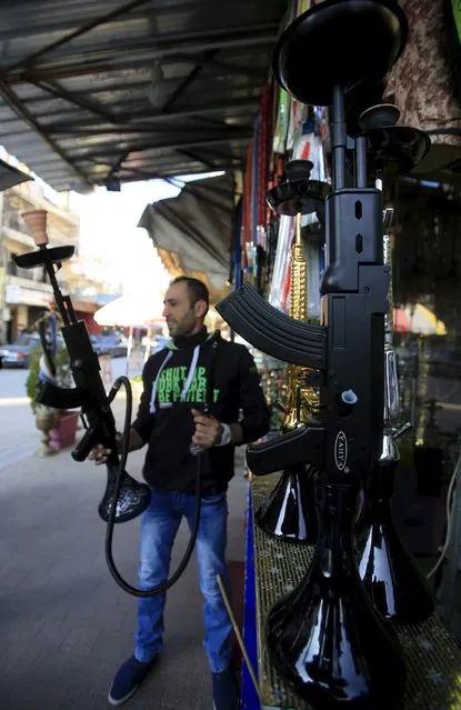 A vendor displays hookahs shaped like rifles inside a souk at the port city of Sidon, southern Lebanon, December 23, 2015. (Photo by Ali Hashisho/Reuters)