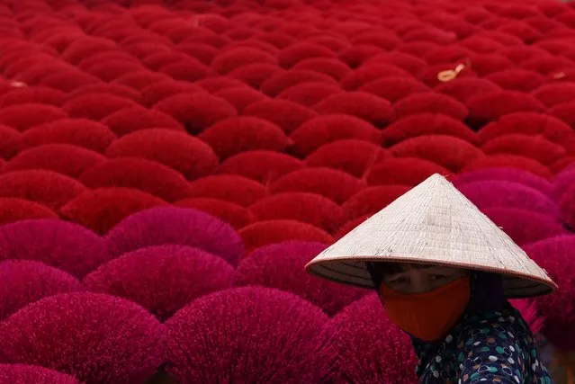 A worker handles dried incense sticks in a courtyard ahead of Lunar New Year celebrations in Quang Phu Cau village outside Hanoi, Vietnam, February 3, 2021. (Photo by Thanh Hue/Reuters)