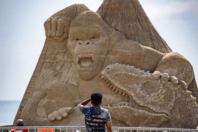 A person stops to look at the almost complete 22-foot (6.7-meter) King Kong centerpiece sculpture from the boardwalk during the Revere Beach International Sand Sculpting Festival in Revere, Massachusetts, on July 25, 2023. This year the festival, taking place July 28-30th, is celebrating the 90th anniversary of King Kong. (Photo by Joseph Prezioso/AFP Photo)