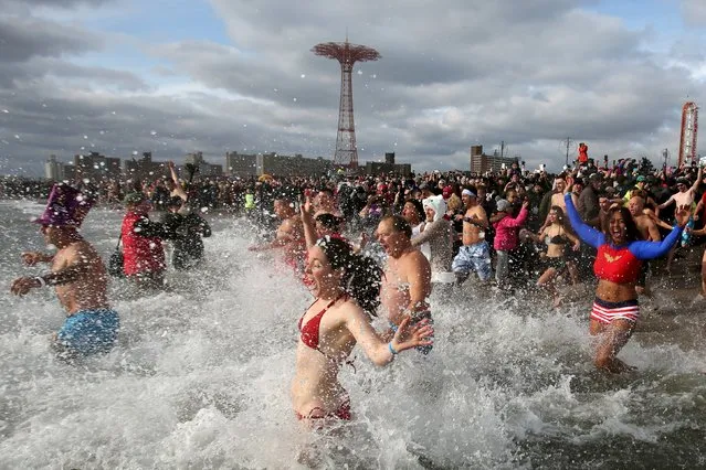 Participants enter the water during the Coney Island Polar Bear Club's annual New Year's Day swim at Coney Island in the Brooklyn borough of New York, January 1, 2016. (Photo by Andrew Kelly/Reuters)