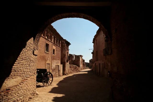 The entrance to the ruins of the old village of Belchite is seen in northern Spain, October 3, 2016. Almost 80 years ago Tomas Ortin fled under the cover of night from his home in the small town of Belchite on Spain's northern plains to escape with hundreds of others from one of the bloodiest battles of the country's civil war. At 94 years old, Ortin now lives just across the road from Belchite, which has lain in ruins since Republican forces attacked it, a symbol of the destruction caused by the 1936-1939 war in which an estimated 500,000 people died. The siege of Belchite was part of a Republican offensive in 1937 to capture Zaragoza, capital of the Aragon region, from the Nationalists led by General Francisco Franco, who went on to win the war and establish a dictatorship that lasted 40 years. Nationalist-controlled Belchite represented a key obstacle given its strategic location in the red-brown hills south of Zaragoza. As many as 6,000 people died defending it before those left surrendered. It became one of the civil war's most infamous battles. (Photo by Andrea Comas/Reuters)