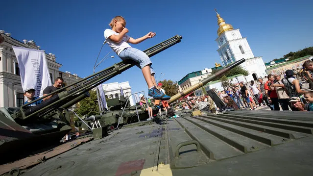 A child plays on a gun at an exhibition of modern weapons and military equipment in Kyiv to coincide with Ukraine's Independence Day in Kiev, Ukraine on August 24, 2018. (Photo by Andriy Dubchak/Radio Free Europe/Radio Liberty)