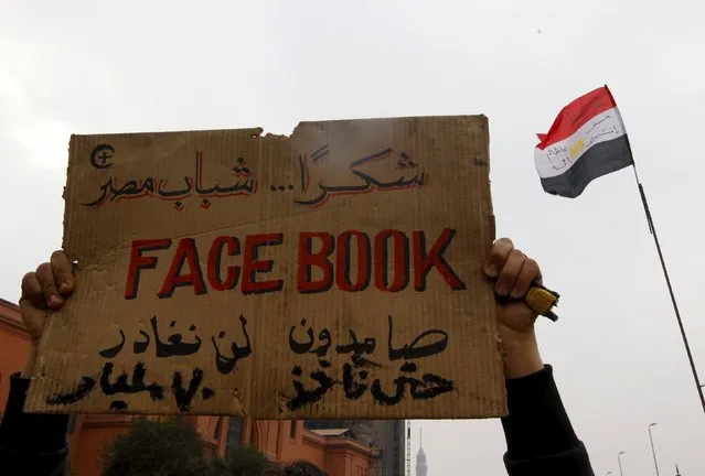 An opposition supporter lifts a placard at the front line near Tahrir Square in Cairo February 7, 2011. (Photo by Yannis Behrakis/Reuters)