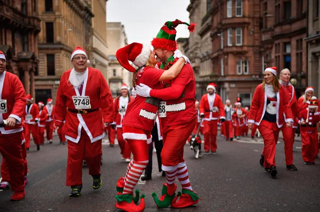 A couple kiss as they joined over seven thousands of members of the public dressed as Santas make their way up St Vincent Street on December 11, 2016 in Glasgow, Scotland. The Santa Dash has been held since 2006 and this year is the 10th anniversary event, in total the event has raised over £100,000 for charities working in and around Glasgow. (Photo by Jeff J. Mitchell/Getty Images)