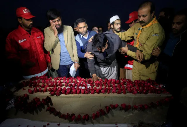 Men mourn over the casket containing the remains of their relative who was killed in a plane crash last week near Abbottabad, during the funeral in Islamabad, Pakistan December 14, 2016. (Photo by Faisal Mahmood/Reuters)