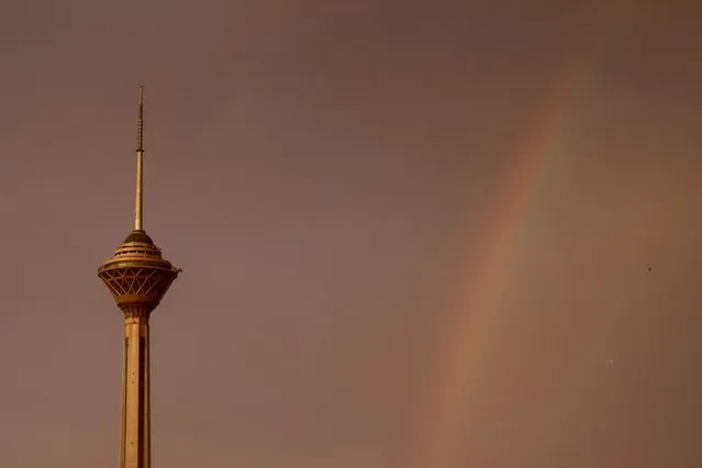 A partial rainbow forms behind Milad tower amid a windy rainstorm in Tehran on August 7, 2023, after days of unprecedented heat in Iran's capital. (Photo by Atta Kenare/AFP Photo)