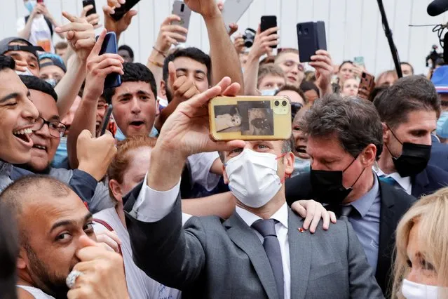 French President Emmanuel Macron takes a selfie as he arrives to visit the castle of Villers-Cotterets which is under renovation, in Villers-Cotterets, on June 17, 2021, during a one-day-visit in northern France dedicated to the Education, reading and language, the third stage of the president's nationwide tour ahead of next year's presidential election. (Photo by Pascal Rossignol/Pool via AFP Photo)