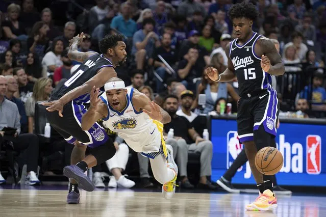 Sacramento Kings guard Davion Mitchell (15) watches as Golden State Warriors guard Jerome Robinson (18) is fouled by Kings guard Malik Monk (0) as he drives to the basket in the first quarter in an NBA preseason basketball game in Sacramento, Calif., Sunday, October 4, 2023. (Photo by José Luis Villegas/AP Photo)