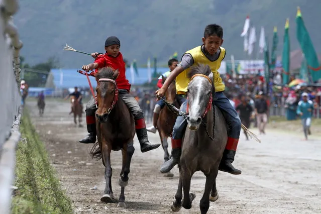 Young jockeys participate in a horse race to mark the 438th anniversary of the town of Takengon, Aceh province March 26, 2015, in this photo taken by Antara Foto. (Photo by Regina Safri/Reuters/Antara Foto)