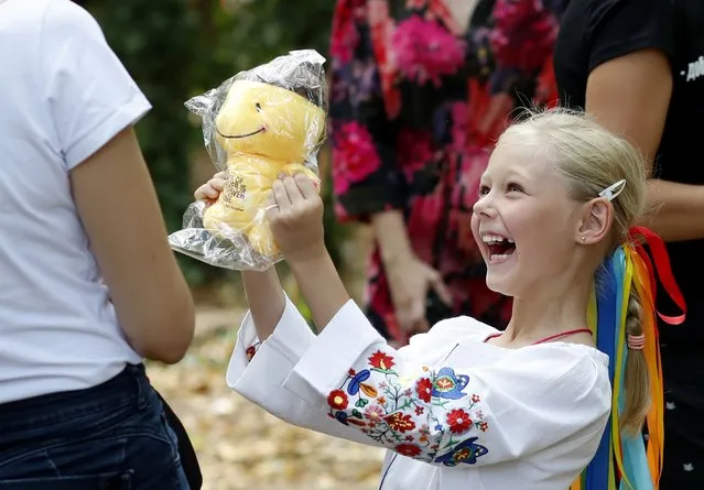 A Ukrainian refugee girl (R) reacts towards her mother (L) while holding a fresh received Teddy bear toy during an event dedicated to the Ukrainian refugee children, organized by the NGO “Terre des Hommes”, part of the celebrations of Ukraine's Independence day in Bucharest, Romania, 24 August 2022. Ukrainians are marking 31 years of independence when it's six months since the Russian invasion of Ukraine started. (Photo by Robert Ghement/EPA/EFE)