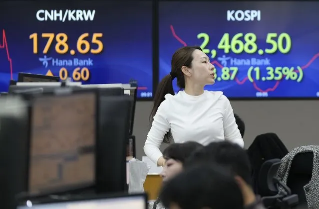 A currency trader works near the screens showing the Korea Composite Stock Price Index (KOSPI), right, at the foreign exchange dealing room of the KEB Hana Bank headquarters in Seoul, South Korea, Tuesday, November 7, 2023. Shares mostly fell in Asia on Tuesday after a mixed close on Wall Street, where wild recent moves calmed a bit at the beginning of a quiet week for data releases. (Photo by Ahn Young-joon/AP Photo)