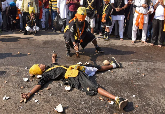 A Sikh performer with his eyes covered by a cloth breaks coconuts closely placed around another performer as they perform Gatkha, a traditional form of martial art, during celebrations to mark the 350th birth anniversary of Guru Gobind Singh, the last and the tenth Guru of the Sikhs, in Nagaon district, Assam, January 7, 2017. (Photo by Anuwar Hazarika/Reuters)