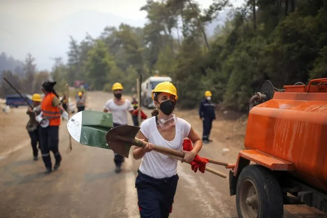 Turkish volunteers run as they fight wildfires in Turgut village, near tourist resort of Marmaris, Mugla, Turkey, Wednesday, August 4, 2021. (Photo by Emre Tazegul/AP Photo)