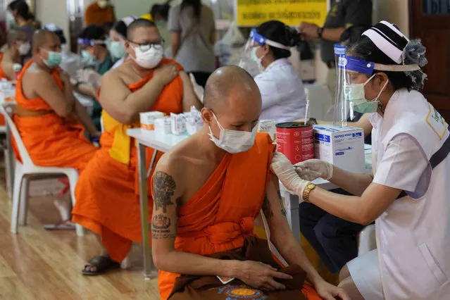 Health workers administer doses of the AstraZeneca COVID-19 vaccine to Buddhist monks at the Wat Srisudaram in Bangkok, Thailand, Friday, July 30, 2021. (Photo by Sakchai Lalit/AP Photo)