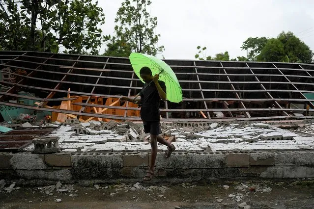 A man walks past an earthquake-destroyed church the morning after Tropical Storm Grace swept over Trou Mahot, Haiti, Tuesday, August 17, 2021, three days after a 7.2-magnitude earthquake. (Photo by Matias Delacroix/AP Photo)