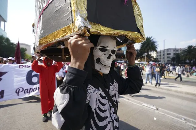 A man wears a skeleton costume during a march to support Mexican President Andres Manuel Lopez Obrador's administration in Mexico City, Sunday, November 27, 2022. (Photo by Fernando Llano/AP Photo)