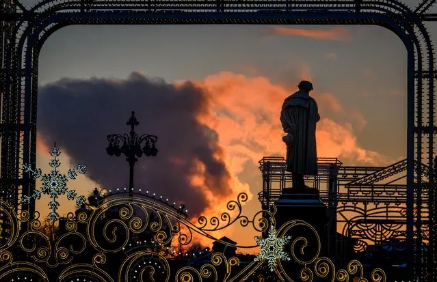 The sun lightens the clouds of steam from a local power plant behind a monument of Russian poet Alexander Pushkin in downtown Moscow on January 9, 2019. (Photo by Mladen Antonov/AFP Photo)