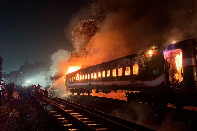 Firefighters try to extinguish a fire caught on a passenger train, ahead of the general election in Dhaka, Bangladesh, on January 5, 2024. (Photo by Mohammad Ponir Hossain/Reuters)