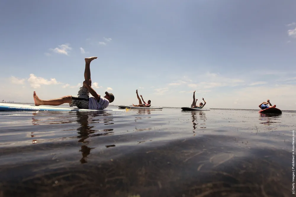 Practioners Enjoy Serenity Of Paddleboard Yoga