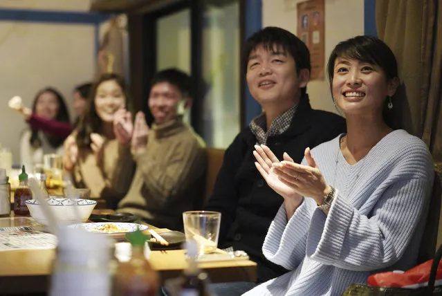 Fans at a restaurant in Tokyo celebrate as Japan's Naomi Osaka wins against Czech Republic's Petra Kvitova at the Australian Open tennis women's final on Saturday, January 26, 2019. (Photo by Eugene Hoshiko/AP Photo)