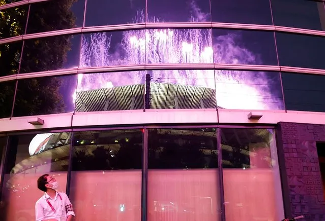 Fireworks from the national stadium are reflected in a building nearby during the opening ceremony of the Tokyo 2020 Paralympic Games at the Olympic Stadium on August 24, 2021 in Tokyo, Japan. (Photo by Issei Kato/Reuters)