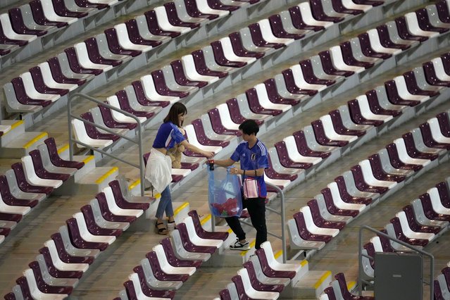 Fans of Japan collects trash after during the World Cup group E soccer match between Japan and Spain, at the Khalifa International Stadium in Doha, Qatar, Friday, December 2, 2022. Japan won 2-1 and qualified to the round of sixteen. (Photo by Themba Hadebe/AP Photo)