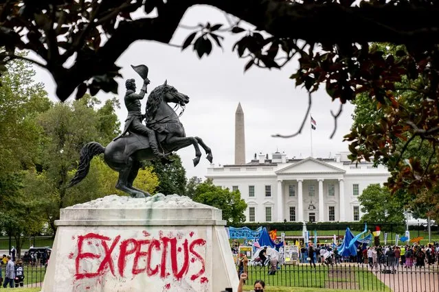 The words “Expect Us” are spray painted on the base of the Andrew Jackson statue in Lafayette Park as Indigenous and environmental activists protest in front of the White House in Washington, Monday, October 11, 2021. The words are part of the phrase “Respect Us, or Expect Us” which indigenous women have been using while protesting oil company Enbridge's Line 3 pipeline through Minnesota. President Joe Biden on Friday issued the first-ever presidential proclamation of Indigenous Peoples' Day, lending the most significant boost yet to efforts to refocus the federal holiday celebrating Christopher Columbus toward an appreciation of Native peoples. (Photo by Andrew Harnik/AP Photo)