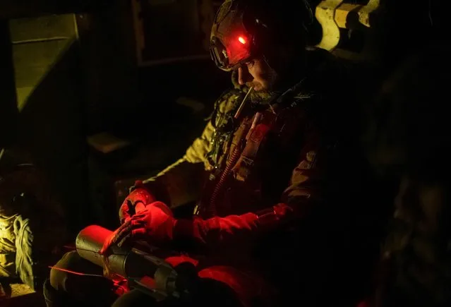A Ukrainian serviceman of the attack drones battalion of the Achilles 92nd brigade, prepares a shell for a drone at his front line position, as Russia's attack on Ukraine continues, near the town of Bakhmut in Donetsk region, Ukraine on February 1, 2024. (Photo by Inna Varenytsia/Reuters)