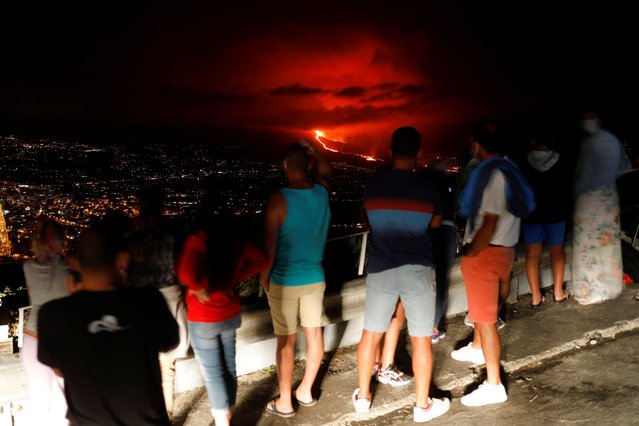 People watch lava following the eruption of a volcano on the Canary Island of La Palma, in Tijarafe, Spain, September 25, 2021. (Photo by Jon Nazca/Reuters)