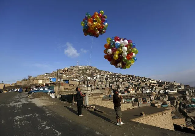 Men hold balloons for sale during celebrations for the Afghan New Year, known as Newroz, in Kabul, Afghanistan March 20, 2016. (Photo by Mohammad Ismail/Reuters)