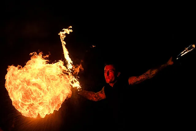 Romanian artist Radu Dima performs his “Smoke and flame on the water” show, on the Dambovita river, in Bucharest, Romania, Friday, September 17, 2021. (Photo by Andreea Alexandru/AP Photo)