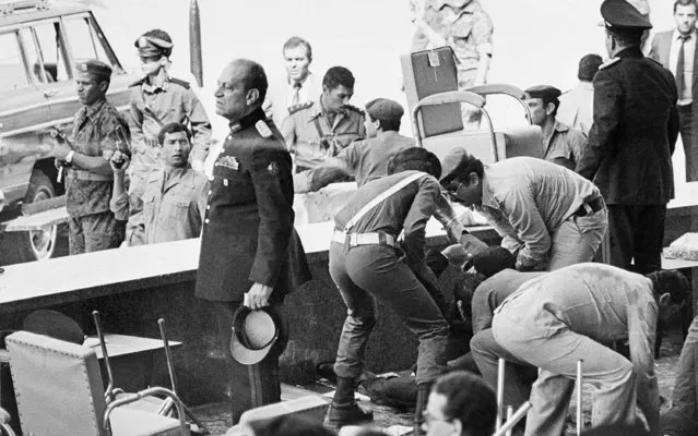 Egyptian soldiers tend to wounded after an attack on the reviewing platform which killed Egyptian President Anwar Sadat in Cairo, Egypt, on October 6, 1981. Six others were also killed by members of the Al Jihad movement, religious extremists within Sadat's army, who opened fire during a military parade commemorating the eighth anniversary of the Arab-Israeli War of Oct. 1973.  (Photo by AP Photo)