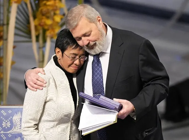Nobel Peace Prize winners Dmitry Muratov from Russia, right, and Maria Ressa of the Philippines embrace during the Nobel Peace Prize ceremony at Oslo City Hall, Norway, Friday, December 10, 2021. The Norwegian Nobel Committee cited Ressa and Muratov's fight for freedom of expression, stressing that it is vital in promoting peace. (Photo by Alexander Zemlianichenko/AP Photo)