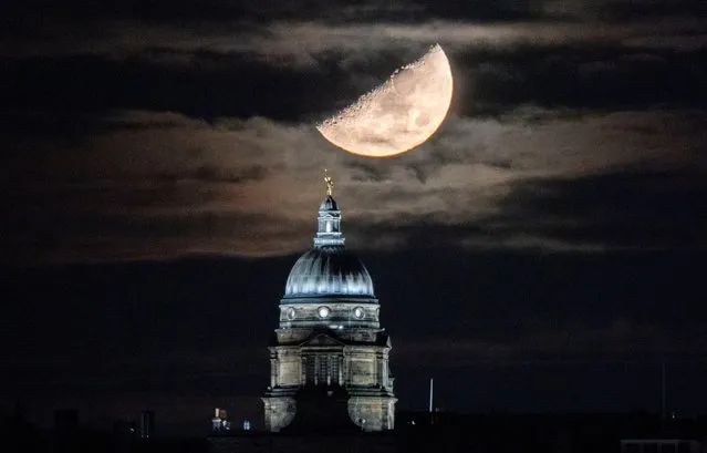 The waxing Moon sets behind the dome of the Old College at the University of Edinburgh, Scotland on Sunday, December 12, 2021. (Photo by Jane Barlow/PA Images via Getty Images)